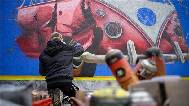 Traumjob Graffiti-Sprayer Mit Farben aus Sprühdosen sprayt Mathias Oppen ein Kunstwerk an eine Wand.
