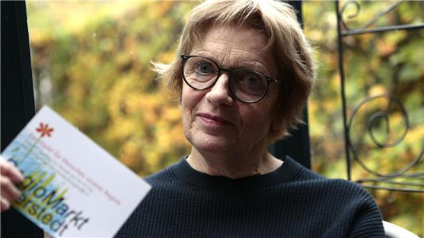 Eine Frau hält eine Karte mit der Aufschrift  "Regiomarkt" in der Hand.