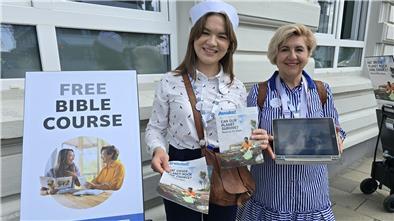 Glaubensoffensive der Zeugen Jehovas: Hunderte Missionare auf der Sail Zwei Frauen in maritimer Bekleidung neben einem Aufsteller
