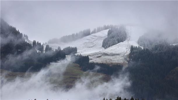 Mit Neuschnee bedeckt sind die nebelverhangenen Berge des Allgäus.