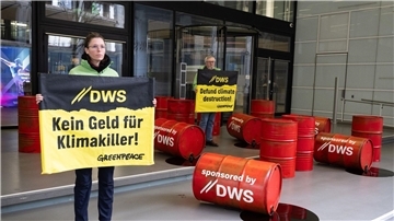 Mit roten Ölfässern protestieren Aktivisten von Greenpeace vor der Zentrale von DWS Investment in Frankfurt gegen die Investitionspolitik des Fonds.