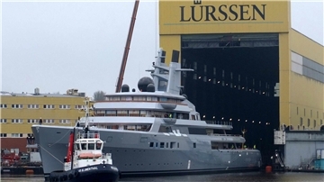 Ein Schlepper zieht eine Yacht aus einem Baudock