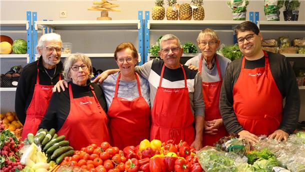 Sechs Menschen mit roten Schürzen