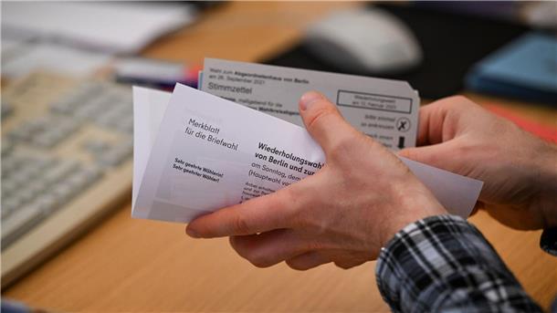 Mitarbeiter bereiten Wahlunterlagen für die Briefwahl vor.