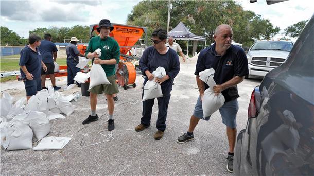Florida bereitet sich auf Hurrikan „Idalia“ vor Mitarbeiter der Park- und Freizeitbehörde von Tampa in Florida helfen Anwohnern beim Verladen von Sandsäcken.