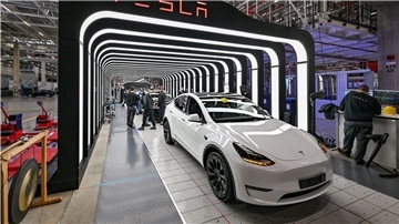 Mitarbeiter der Tesla Gigafactory Berlin Brandenburg arbeiten an der Endkontrolle der fertigen Elektrofahrzeuge vom Typ Model Y.