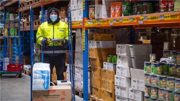 Mann in Lagerhalle. Mitarbeiter Ralf Busch stellt die Bestellungen im Lager der Firma Feddersen zusammen. Auch in diesem Corona-Dezember ist weniger zu tun als normalerweise zum Jahresschluss.