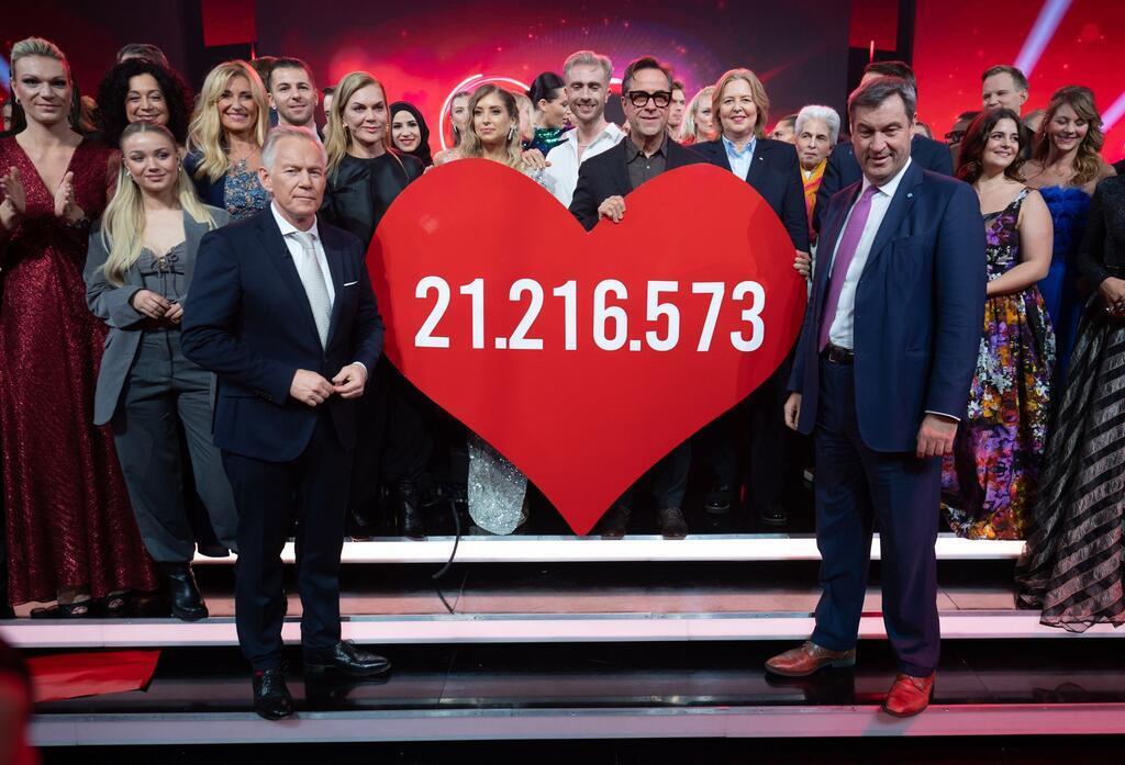 Moderator Johannes B. Kerner (l) und Markus Söder (CSU) freuen sich über die hohe Spendensumme.