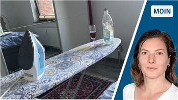 Ein Bügelbrett mit Bügeleisen und einem Glas Rotwein.
