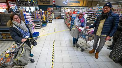 Monika Miesner (links) und Anja Neumann mit Thomas Gries zeigen im E-Center Roter Sand, was zwei Meter Abstand im Alltag im Supermarkt bedeuten.