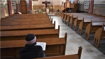 Eine Kirchenbesucherin in St. Jakobi hat sich in eine Wolldecke gehüllt
