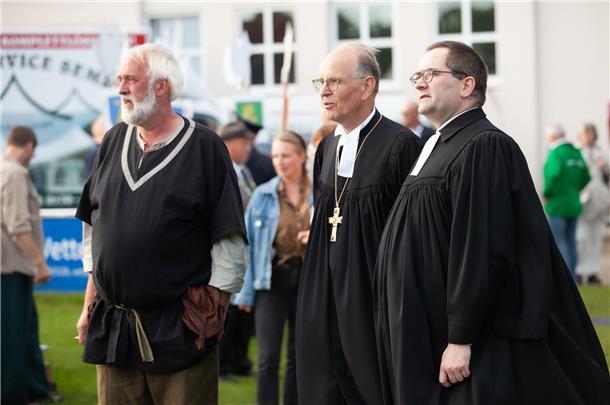 Impressionen aus mittelalterlichem Mulsum: Hartes Ringen beim Wurster Dreikampf Mulsums Ortsvorsteher Udo Skeraitis (v.l.) zeigt Landesbischof Ralf Meister und Albrecht Preisler, Superintendent des Kirchenkreises Wesermünde, was die Wurster Bürger für die Historischen Festtagen zum 500. Jahrestag der Schlacht um die Wurster Freiheit auf die Beine gestellt haben.