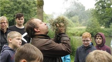 Museumsmitarbeiter Lothar Safier nimmt die Teilnehmerinnen und Teilnehmer mit ins Steinzeitlager.