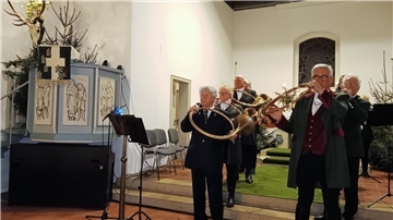Bläser musizieren in einer Kirche.