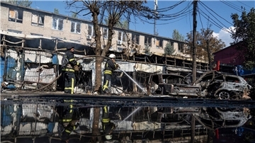 Nach dem Beschuss eines Marktplatzes in der ostukrainischen Stadt Kostjantyniwka löschen Rettungskräfte ein Feuer.
