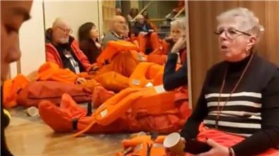 Nach dem „Wellentreffer" müssen die Passagiere der „Maud" vor den Kabinen warten und Überlebensanzüge anziehen.
