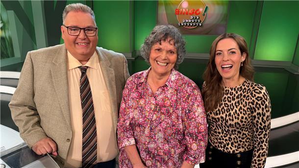 Ein Mann und zwei Frauen stehen in einem Fernsehstudio.