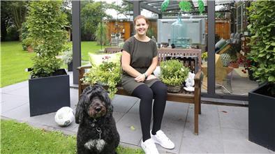 Kim Terhaag sitzt auf einer Bank im Garten.