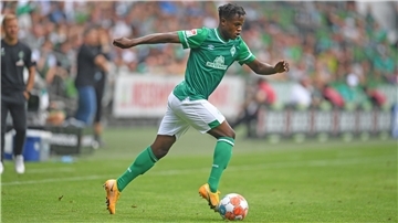 Ein Fußballer mit einem Ball am Fuß.