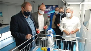 Nach kurzer Programmierung ist der humanoide Roboter Nao auf dem Weg, um Geestlands Bürgermeister Thorsten Krüger (links) den Stoffbären in die Hand zu drücken. Aufmerksame Beobachter sind (von links) Rafael Platek, Horst Lüdtke, Uwe Nixdorf und Engin Öztürk, Projektleiter im Sciene Truck. Foto Schoener