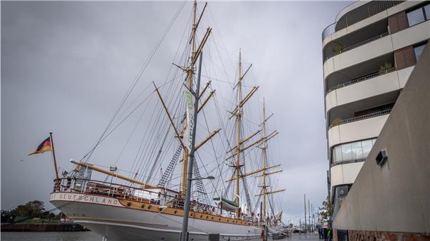 Segelschiff vor Haus.