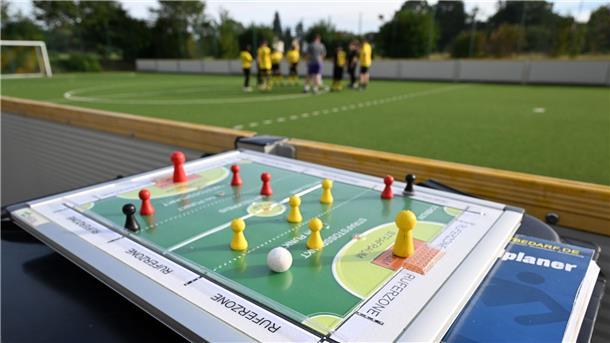 Fan-Jubel verboten: Blindenfußball kämpft um Aufmerksamkeit Neben der ertastbaren Taktiktafel, gibt es noch andere Hilfsmittel auf dem Platz, um den Kickern das faire Spiel zu ermöglichen.