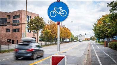 Neue Verkehrszeichen weisen auf Rad- und Fußweg entlang der Kennedybrücke auf die geänderte Regelung hin. Die weißen Linien sind schwer zu entfernen und sollen zunächst mit Kreuzen als ungültig markiert werden.