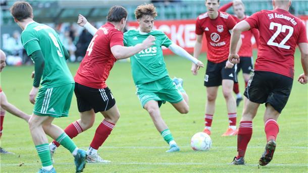 Aufgeladenes Spiel im Waldstadion - Heeslingen II siegt mit 4:0 Ein Mann holt mit dem Bein aus und ist dabei den Ball, der vor ihm liegt zu schießen. Um ihn herum sind Spieler der gegnerischen Mannschaft.