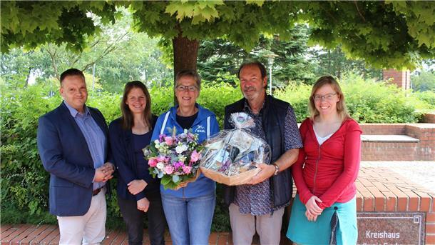 Drei Frauen und zwei Männer stehen unter einem Baum.