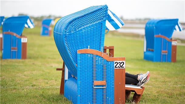 Strandkörbe an der Küste. Aus Sicht der Grünen müssten Urlaubsorte finanziell besser unterstützt werden.
