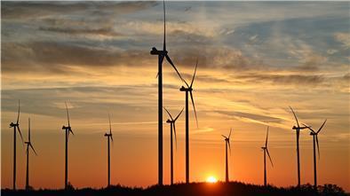 Windparks im Schatten der aufgehenden Sonne.