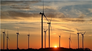 Windparks im Schatten der aufgehenden Sonne.