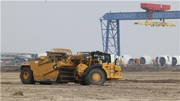 Ein gelbes Fahrzeug auf Sand.