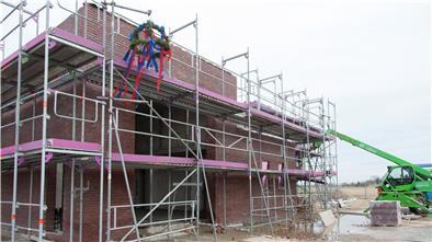 Noch vor den verschärften Ausgangsbeschränkungen haben Dorfbewohner den Richtkranz am neuen Feuerwehrhaus von Cappel-Neufeld aufgehängt.