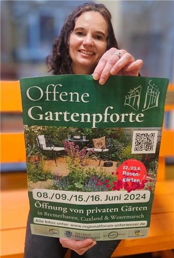 Nordenhams Pressesprecherin Ivonne Solbrig hält ein Plakat der "Offenen Gartenpforte" 2024 in die Kamera