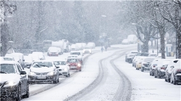 Nur langsam kommen Autos in der Kölner Innenstadt im dichten Schneetreiben voran.