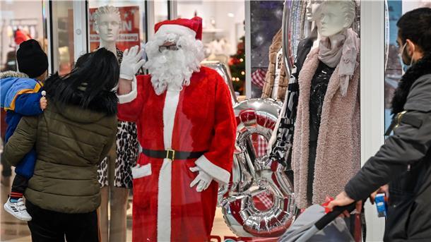 NZ-Redakteurin Ursel Kikker winkt aus dem Schaufenster bei Mode Steffen im Columbus-Center als Weihnachtsmann den Passanten zu.