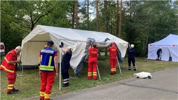 Ob rote oder blaue Uniform - die Zusammenarbeit beim Aufbau der Zelte für die medizinische Versorgung läuft reibungslos.