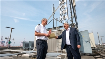 Oberbürgermeister Melf Grantz (SPD) begutachtet mit Feuerwehrchef Jens Cordes (links) die neue, auf dem Gatehouse 4 im Hafen montierte, 120 Dezibel laute Sirenenanlage.