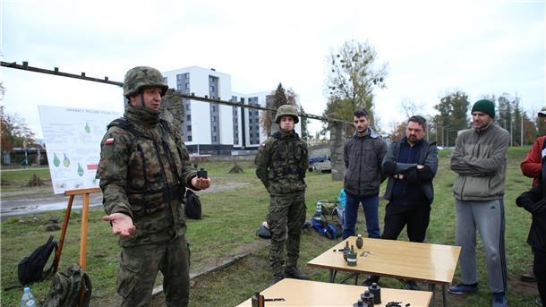 Kriegsangst in Polen: Bürger trainieren mit der Armee Oberfeldwebel Mariusz Starosz (l) erklärt auf einem Übungsplatz der polnischen Armee Bürgern den richtigen Umgang mit einer Handgranate.