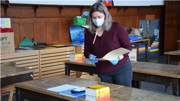 Oberstufenkoordinatorin Sandra Kaufhold muss die Bögen mit den diesjährigen Erdkundeaufgaben maskiert und mit Gummihandschuhen verteilen. Foto: Teichmann