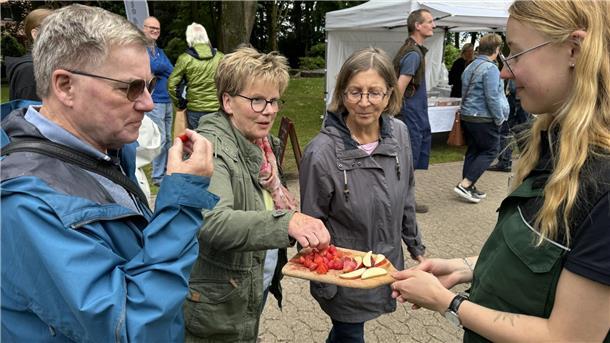 Menschen probieren Obst und Gemüse. 