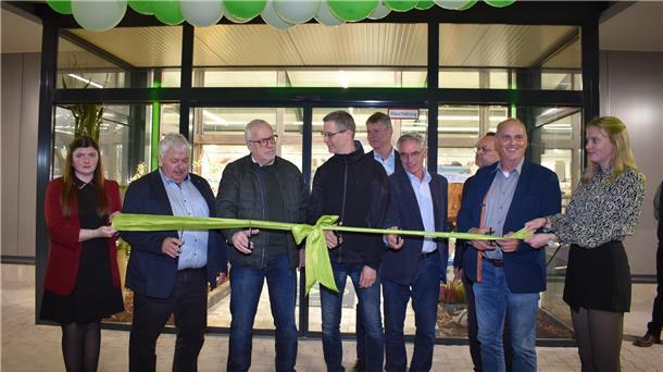 Gruppe Menschen bei eienr Eröffnung. Ein Band wird zerschnitten.