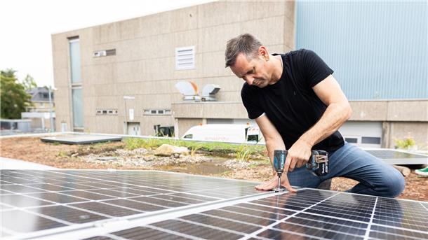 Olaf Lies, damals noch als Wirtschaftsminister, montiert ein Solarmodul auf ein Dach. (Archivbild)