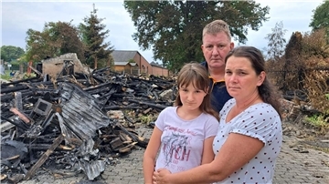 Olesya (rechts) und Heinz-Georg Mehrtens sowie Tochter Anna stehen vor den Trümmern der abgebrannten Scheune neben ihrem Wohnhaus in Driftsethe.