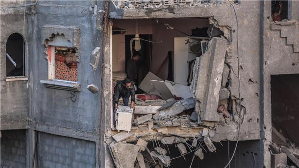 Palästinenser inspizieren nach einem israelischen Angriff die Schäden an einem zerstörten Gebäude in Rafah.