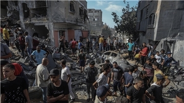 Palästinenser schauen sich die Zerstörungen rund um ein Wohnhaus nach einem israelischen Luftangriff im südlichen Gazastreifen an.