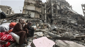 Palästinenserinnen sitzen auf Trümmern im Flüchtlingslager Nuseirat im Gazastreifen nach dem Abzug der israelischen Streitkräfte (IDF).