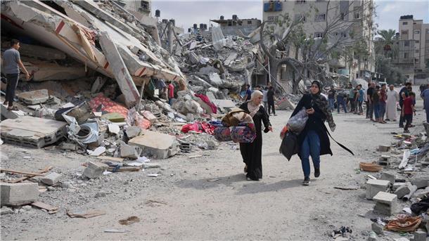 Klinik in Gaza getroffen - Jordanien sagt Biden-Treffen ab Palästinensische Frauen gehen in Nuseirat im Gazastreifen an Gebäuden vorbei, die bei israelischen Luftangriffen zerstört wurden.