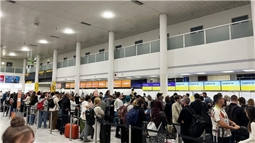 Passagiere in Warteschlangen am Flughafen Gatwick im South Terminal.